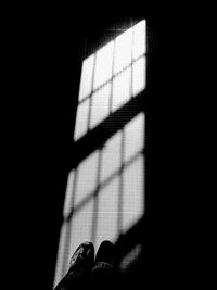 Low section of person shadow on tiled floor