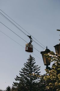 Low angle view of overhead cable cars against sky