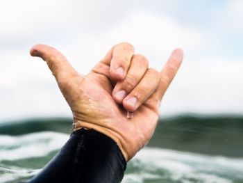 Cropped image of man hand against sea