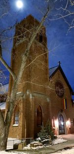 Low angle view of illuminated building against sky at night