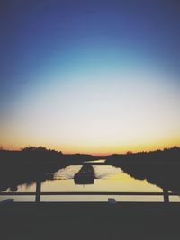 Scenic view of lake against clear sky during sunset