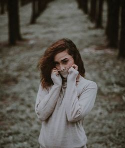 Portrait of young woman standing in snow