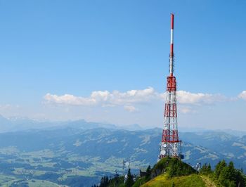 Communications tower and mountains against blue sky