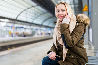 Full length of woman at railroad station during winter