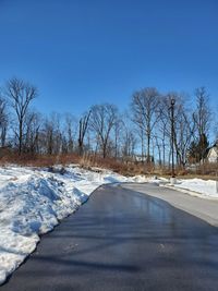 Scenic view of snow covered landscape against clear blue sky