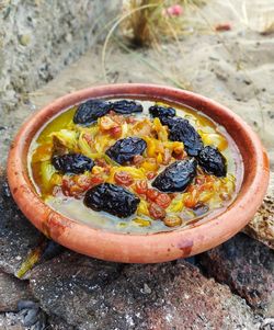 High angle view of fruits in bowl on rock