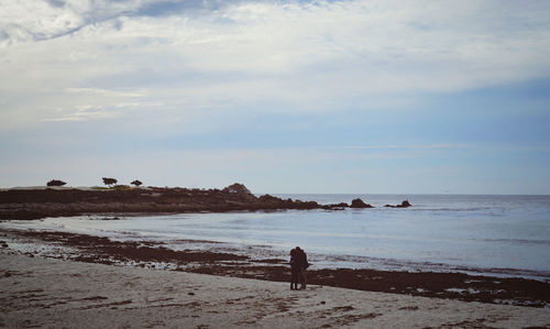 Man standing on beach against sky