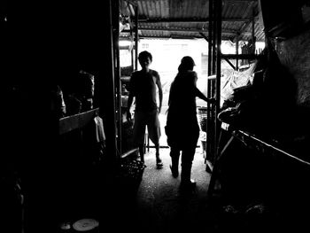 Full length of man and woman standing on tiled floor