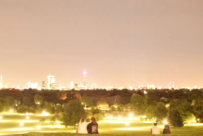 Illuminated city against sky at night