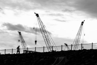 A man jogging under cranes at construction site