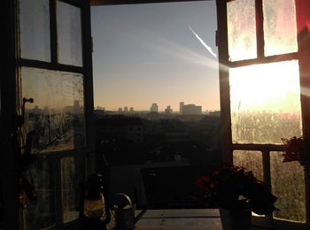 Cityscape against sky seen through balcony window