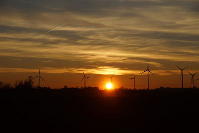 Silhouette of wind turbines at sunset