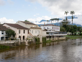 Buildings by lake against sky