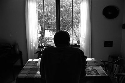 Rear view of woman standing against white wall