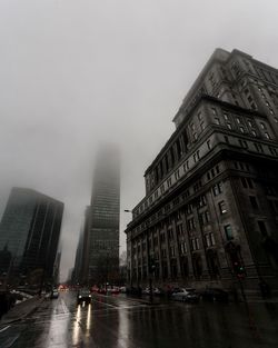 Buildings in city against sky during rainy season