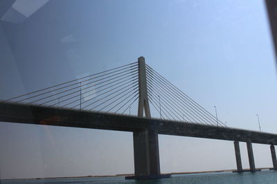 Low angle view of suspension bridge against sky