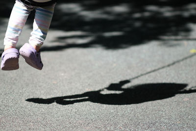 Low section of girl playing on swing at playground