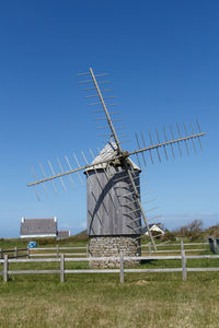 Traditional windmill on field against clear sky