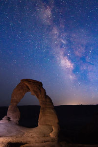 Scenic view of rock formation against sky at night