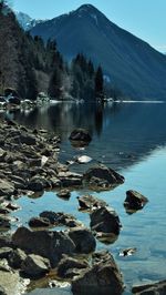 Scenic view of lake by mountain against sky