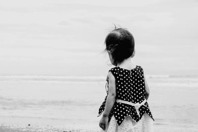 Rear view of woman standing on beach