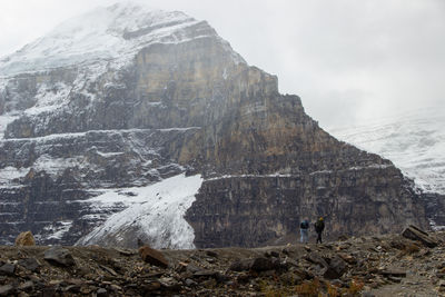 Hikers going up to the canadian rockies. with the background of the snowy mountain 