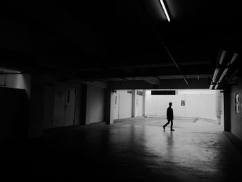 Silhouette man walking in parking garage
