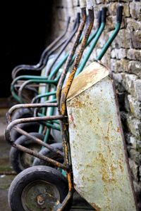 Rusty wheelbarrows by brick wall