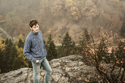 Portrait of a young man standing on mountain in autumn
