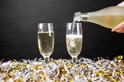 Glass of wine bottles against black background