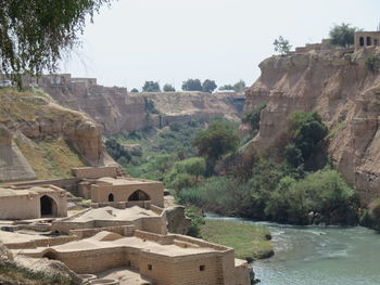 Scenic view of river by cliff against clear sky