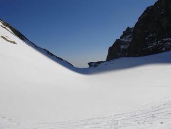 Scenic view of snow covered mountains against clear blue sky