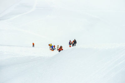People in snow on mountain road