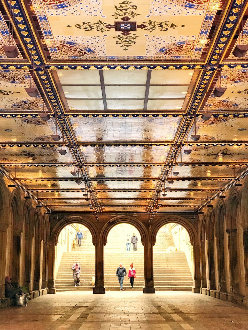 PEOPLE WALKING IN CORRIDOR OF HISTORICAL BUILDING