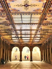 People walking in corridor of historic building