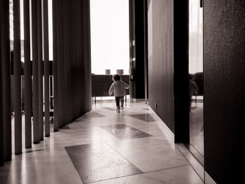 Rear view of people walking in corridor