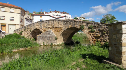 Arch bridge over river against sky