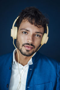 Portrait of young man against black background