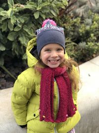 Portrait of smiling girl standing against plants