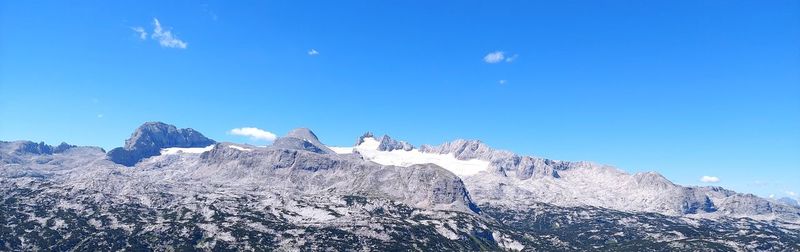 Panoramic view of snowcapped mountains against blue sky