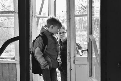 Siblings standing at doorway