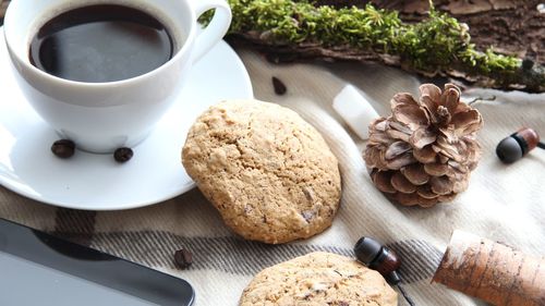 High angle view of coffee and cookies on table