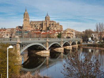 Bridge over river against cloudy sky