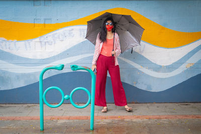 Woman standing against graffiti wall