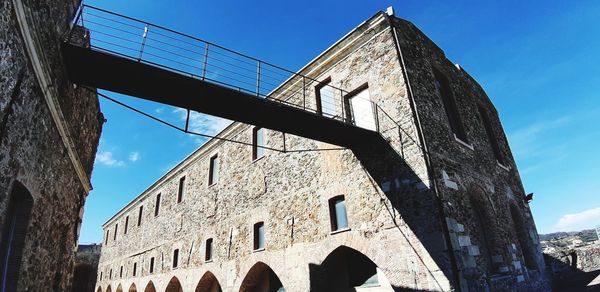 Low angle view of old building against blue sky