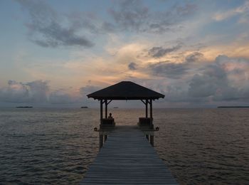 Pier over sea against sky during sunset