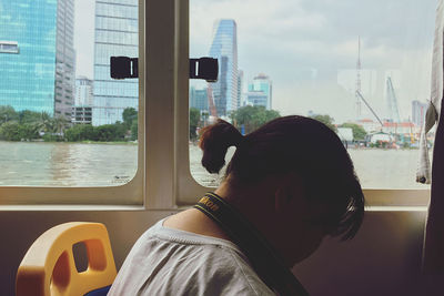 Side view of woman by glass window in boat
