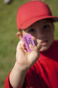 Young boy holding his coupon for the snack shack after his little league game