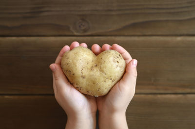 Cropped image of hand holding heart shape cookies