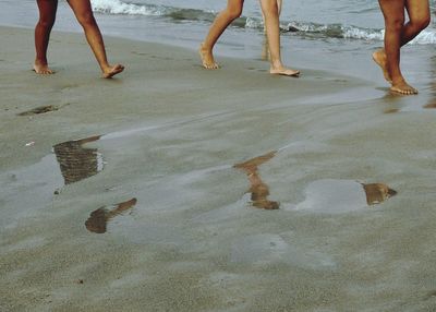 Low section of people standing on beach